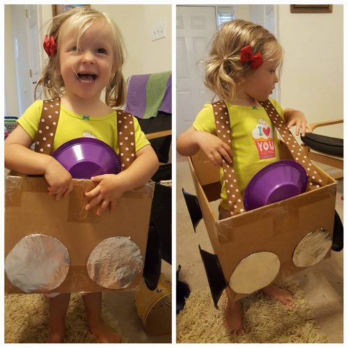 girl driving car made out of cardboard box