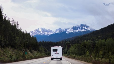rv traveling to snow capped mountains
