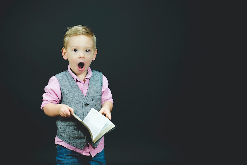 boy with book and shocked expression on face