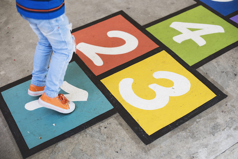 Young kid playing hopscotch