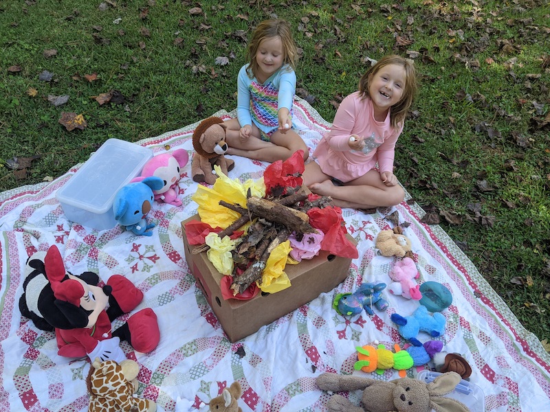 2 girls with homemade campfire and toys