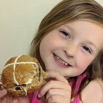 smiling girl with hot cross bun